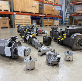 The blurred warehouse contains various mechanical parts and equipment.