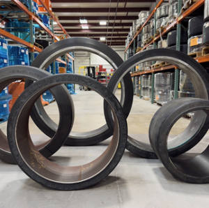 The image is a low-resolution photograph of industrial shelving containing various products such as tires and other goods.